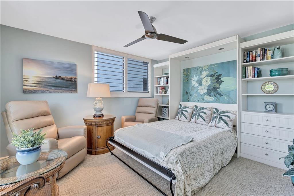 Carpeted den with ceiling fan and Murphy Bed