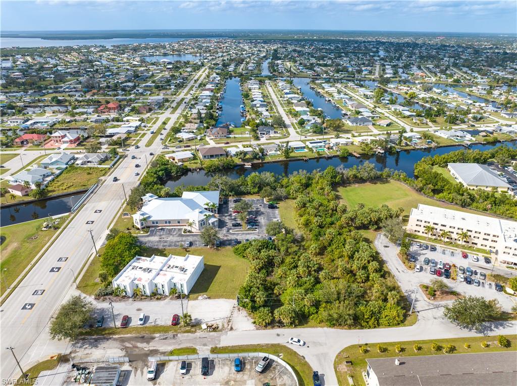 Aerial view of property and surrounding area with a nearby body of water