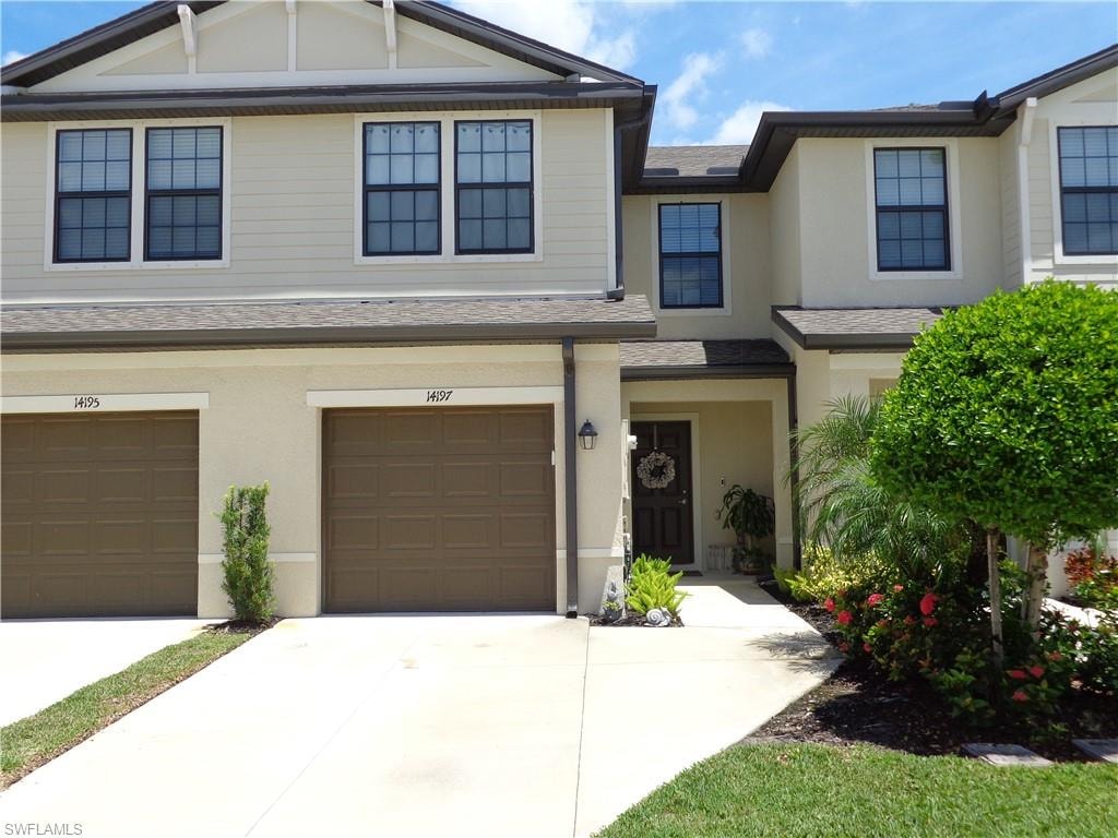 Craftsman house with driveway, roof with shingles, stucco siding, and a garage