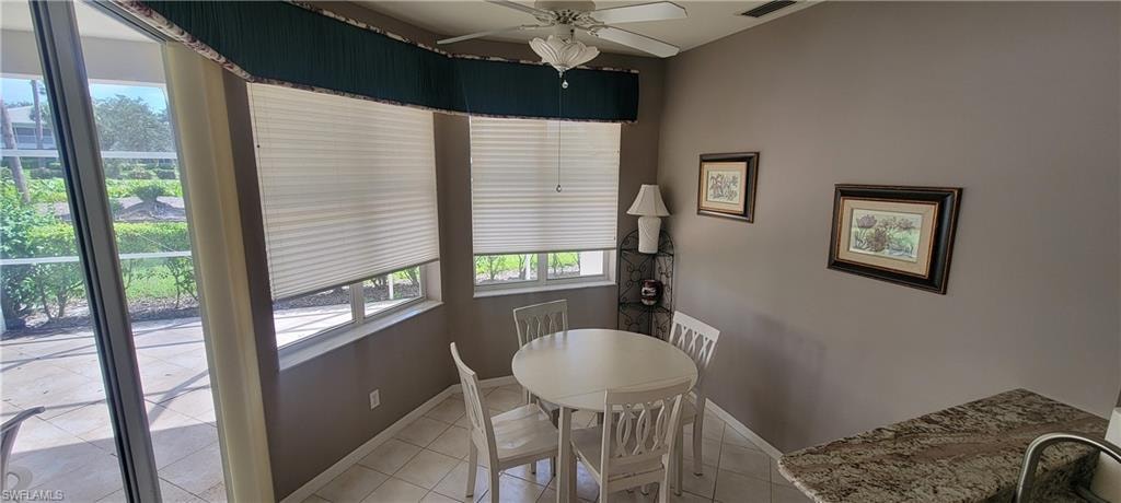 Dining area featuring light tile patterned flooring and ceiling fan