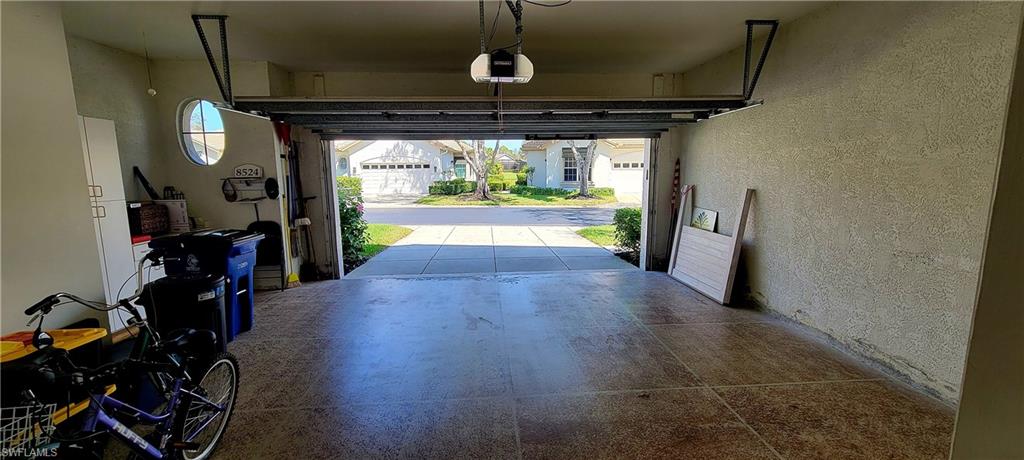 Garage featuring a textured wall and a garage door opener