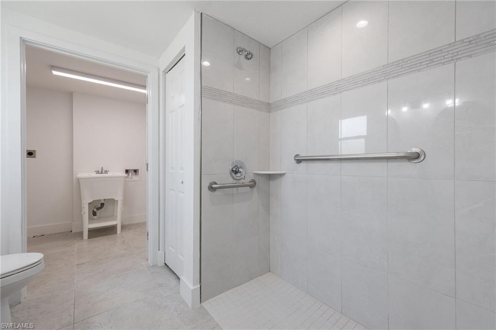Bathroom with a tile shower and light tile patterned floors