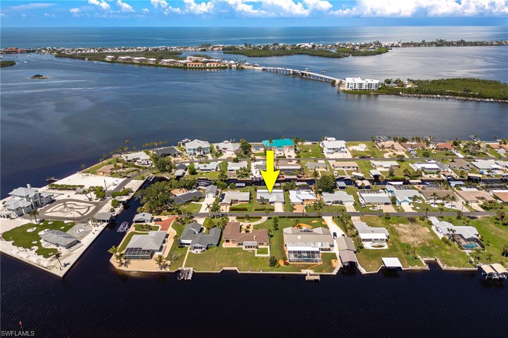 Aerial perspective of suburban area with a notable bridge and a large body of water