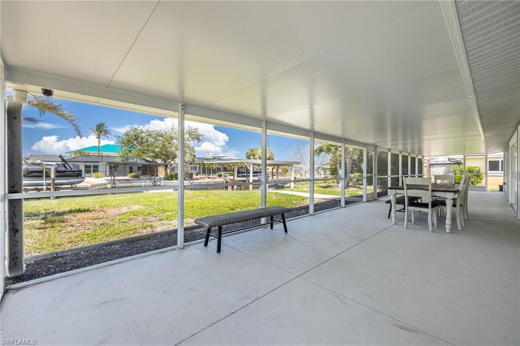 Screened covered lanai with water views, ideal for outdoor dining and relaxation.