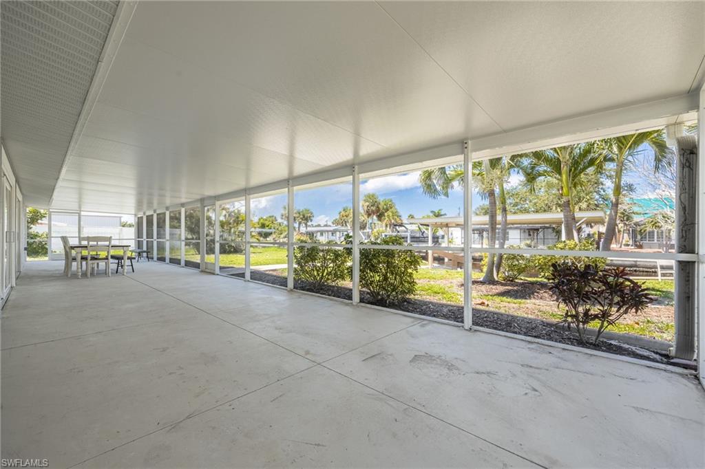 Spacious covered lanai with screened enclosure, perfect for outdoor dining and relaxing.