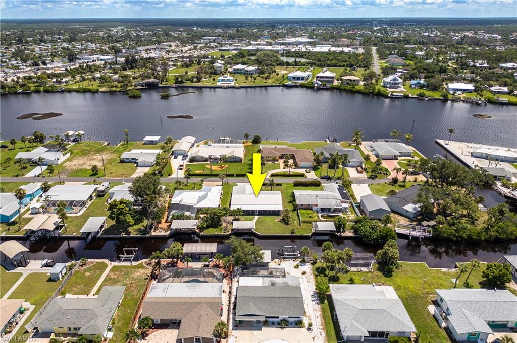 Aerial view of property's location with a large body of water and nearby suburban area