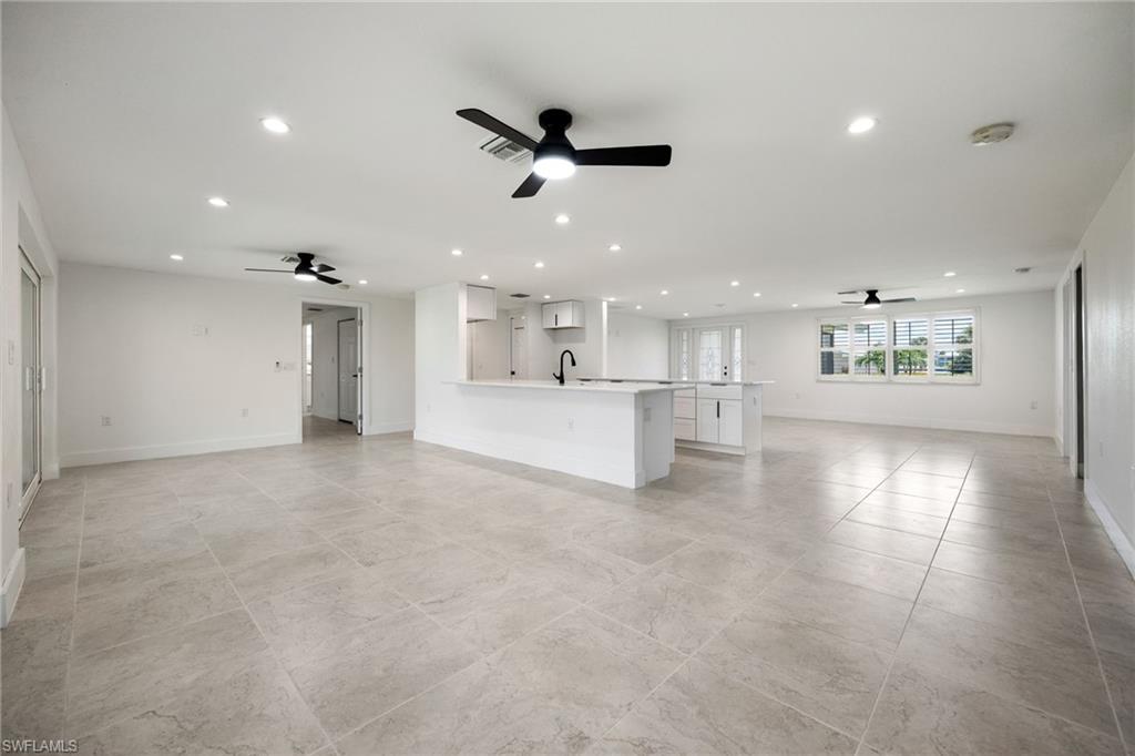Unfurnished living room with a ceiling fan and recessed lighting
