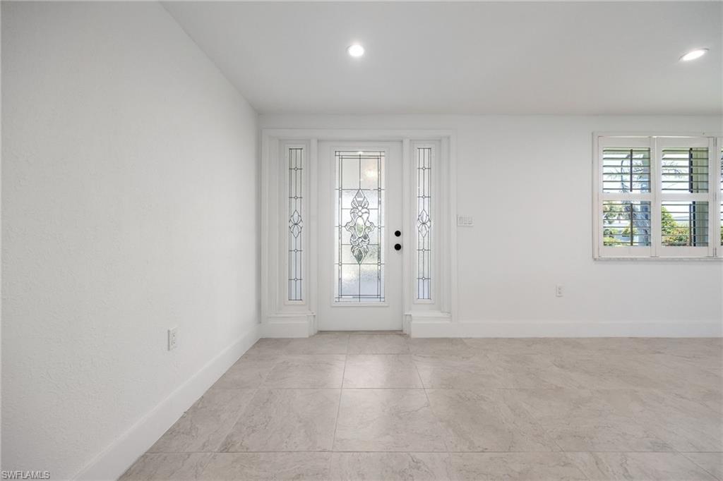 Bright and welcoming entry featuring elegant glass panel door with side panels