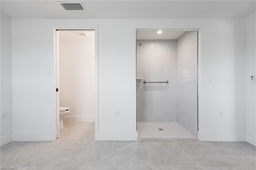 Guest bedroom ensuite with walk-in shower, separate toilet, and vanity area.