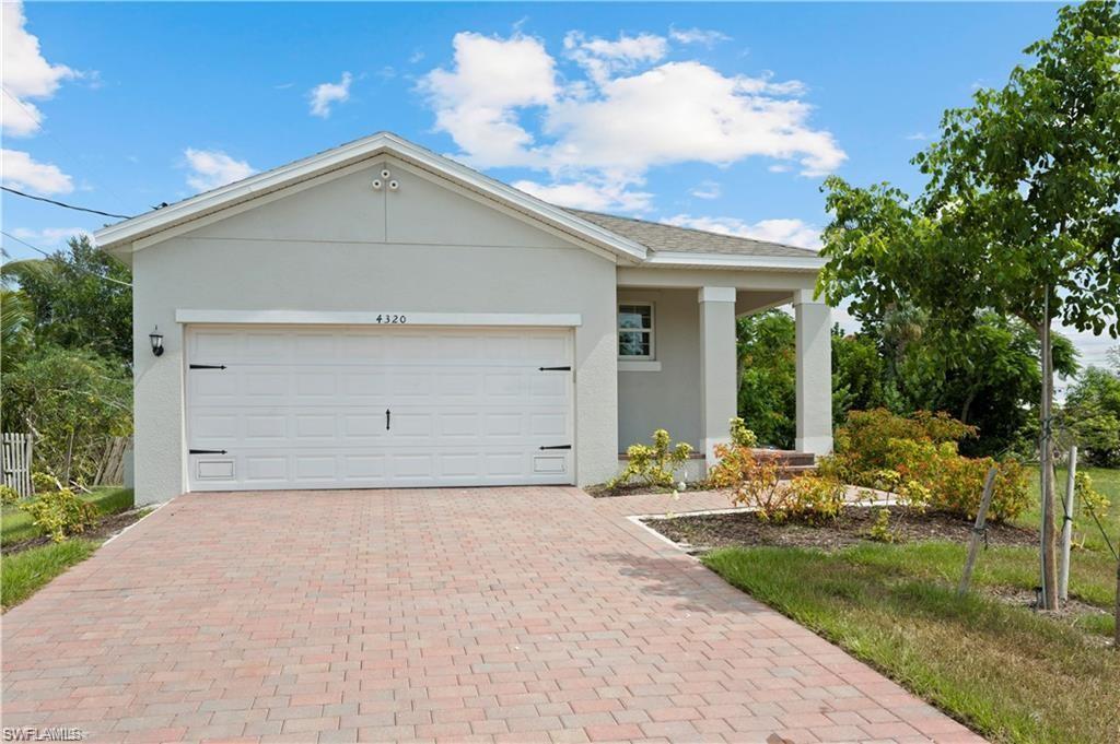 Single story home with stucco siding, decorative driveway, and an attached garage