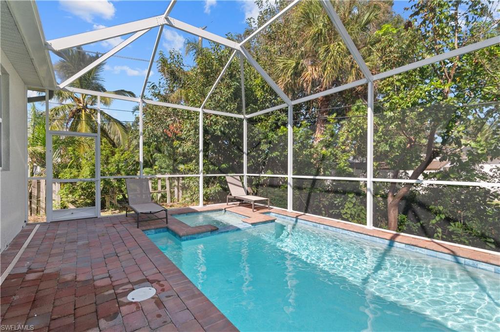 View of swimming pool featuring a patio, a lanai, and a pool with connected hot tub