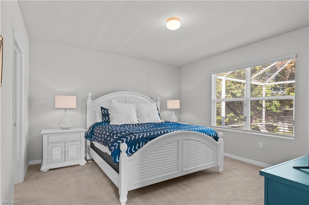 Bedroom featuring light colored carpet and baseboards