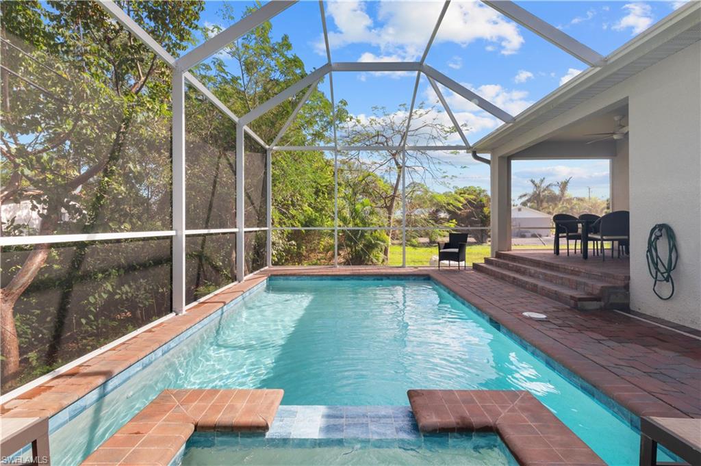 View of swimming pool with a patio area, a pool with connected hot tub, a ceiling fan, and a lanai