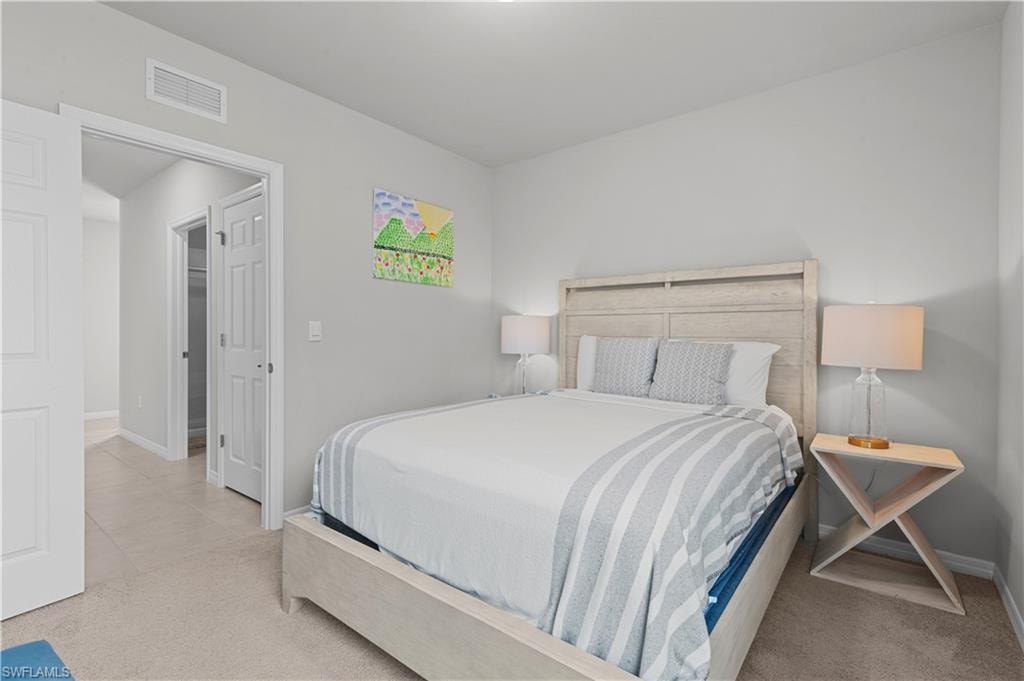 Carpeted bedroom with baseboards and tile patterned floors