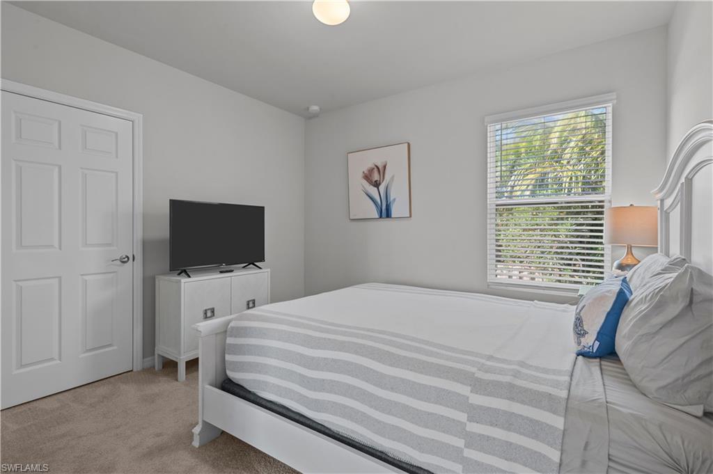Bedroom featuring light carpet