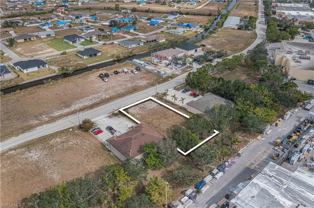 Aerial view of property and surrounding area with nearby suburban area