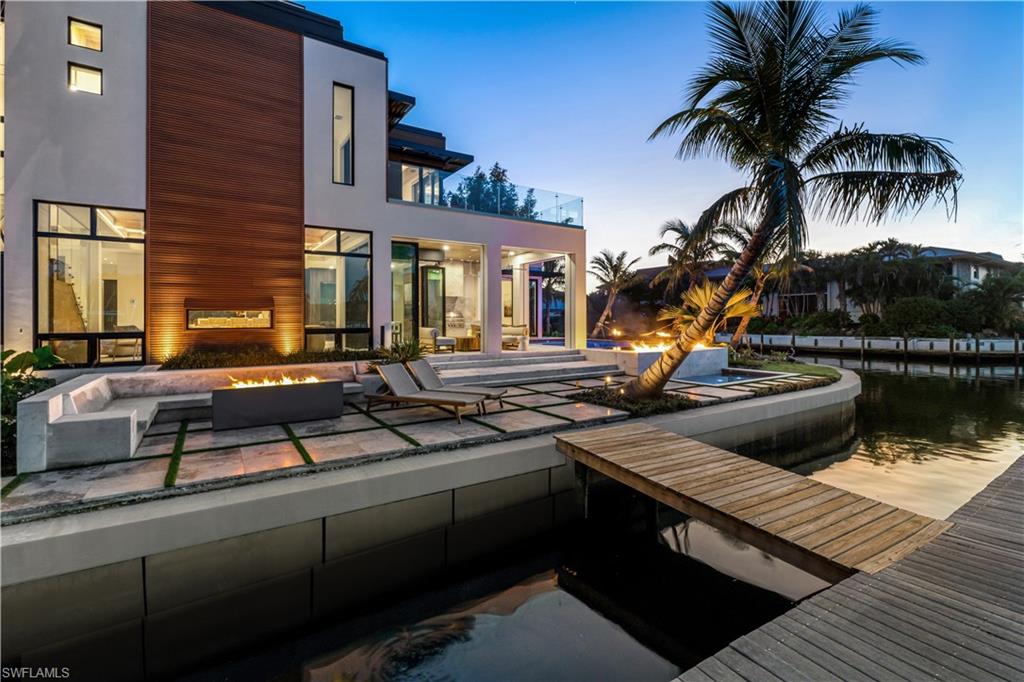 Pool at dusk featuring an outdoor fire pit and a patio area