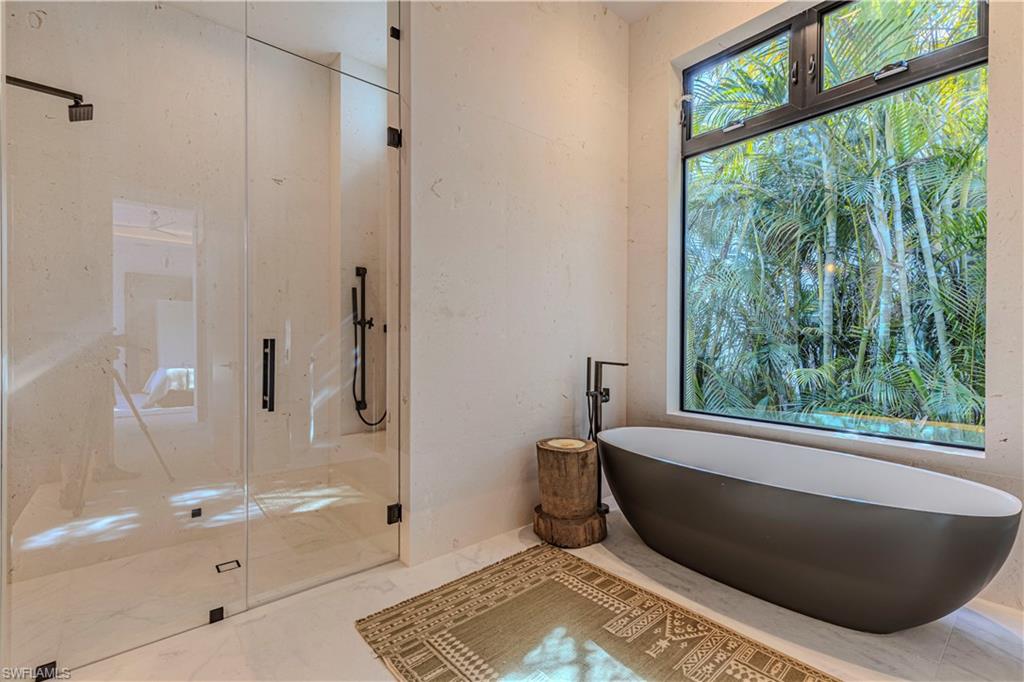 Waster bath with steam shower, oversized tub, full travertine stone wraped wall and window