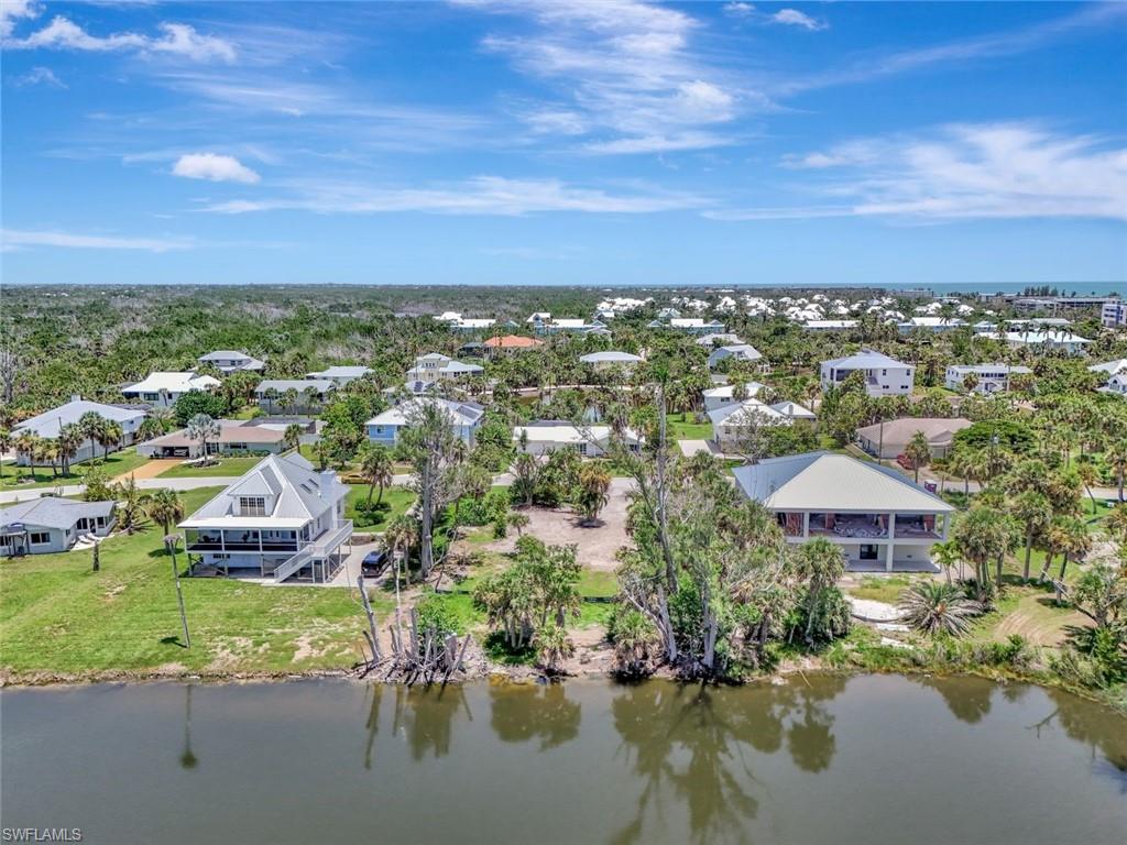 Aerial perspective of suburban area featuring a nearby body of water