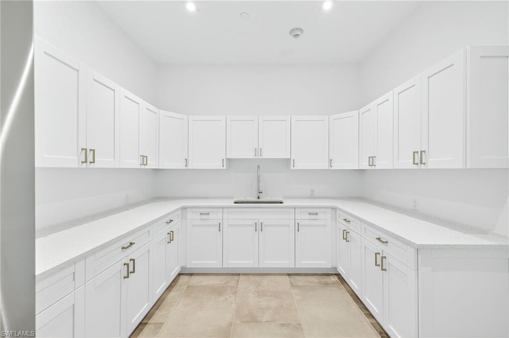 Kitchen with light countertops and white cabinetry