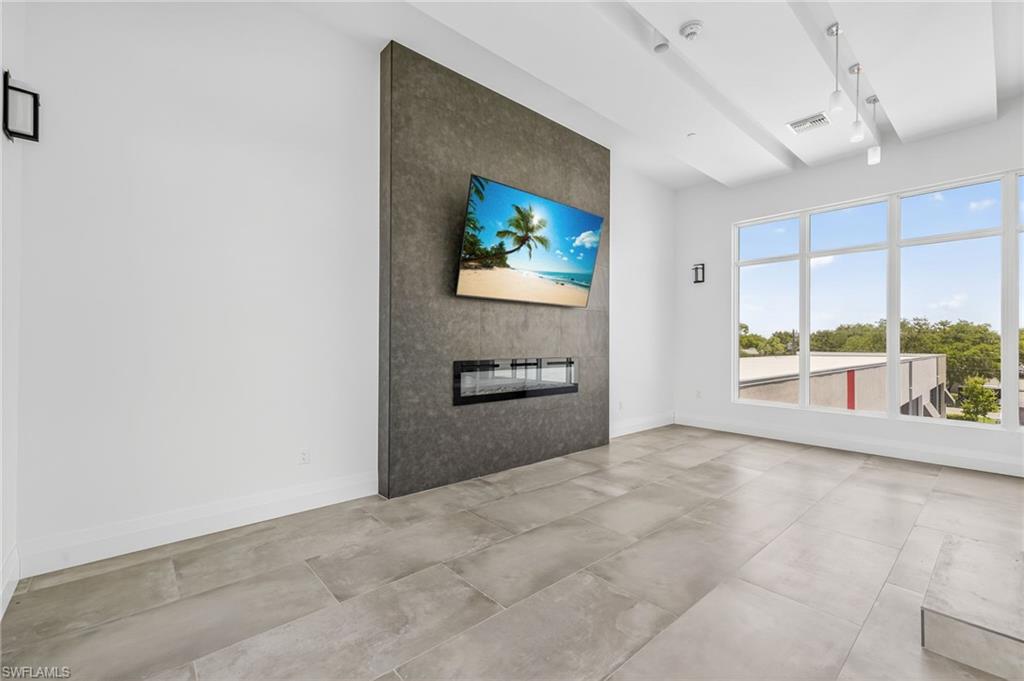 Unfurnished living room featuring a fireplace and baseboards