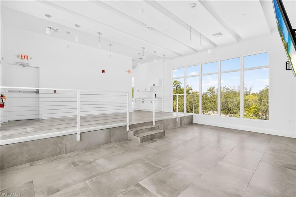Unfurnished sunroom featuring beam ceiling