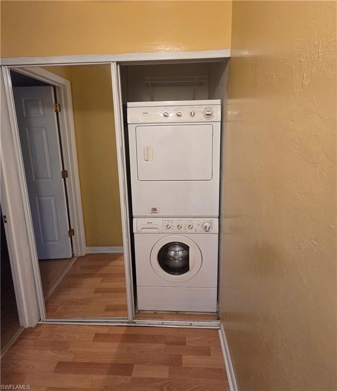 Laundry room with estacked washer and dryer and wood finished floors