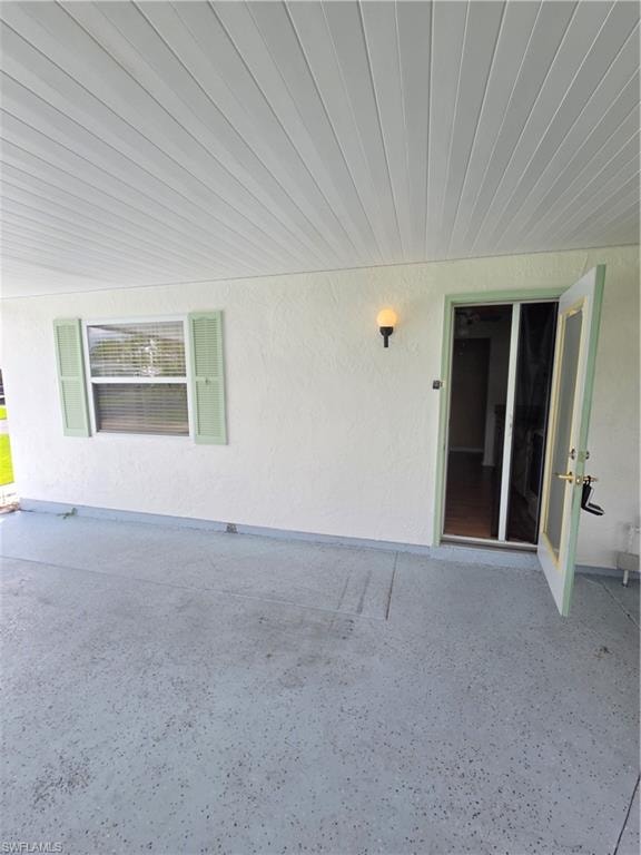 View of home's exterior featuring a lawn, an attached carport, and concrete driveway