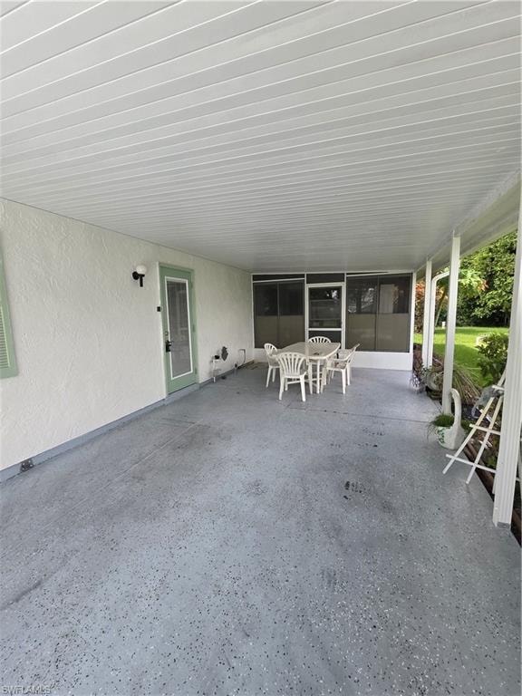 View of front of home featuring a front lawn, driveway, and an attached carport