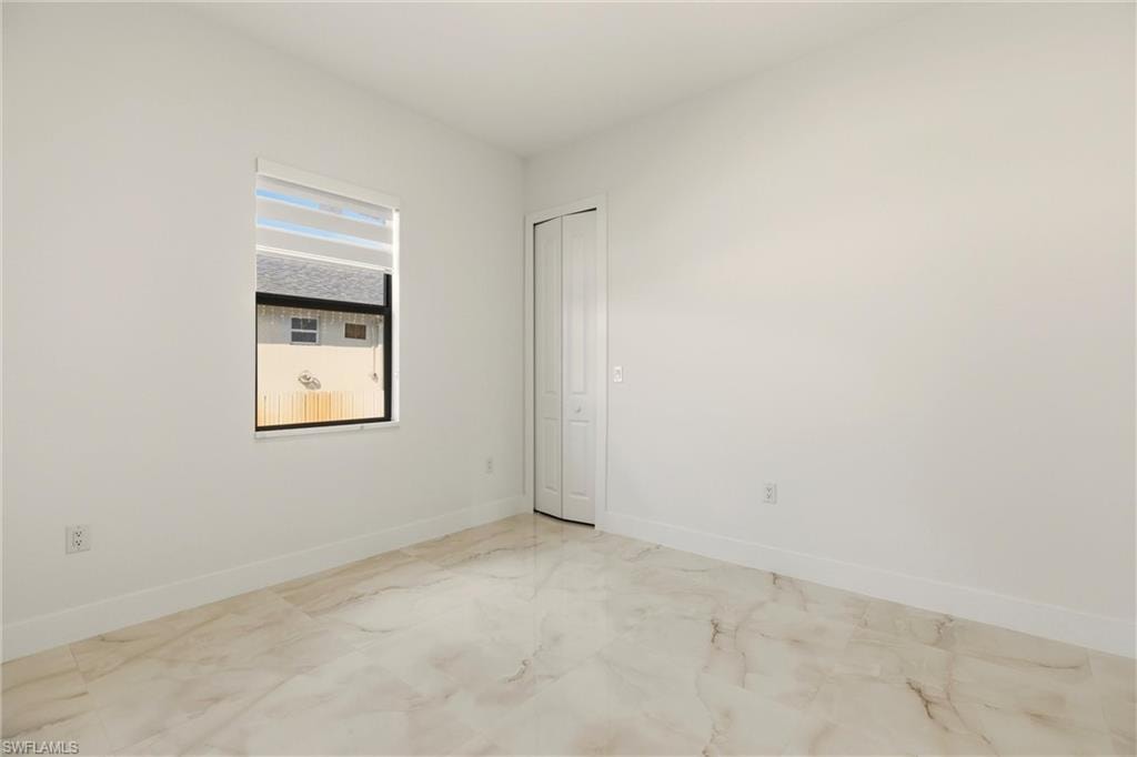 Spare room with baseboards and light marble finish flooring