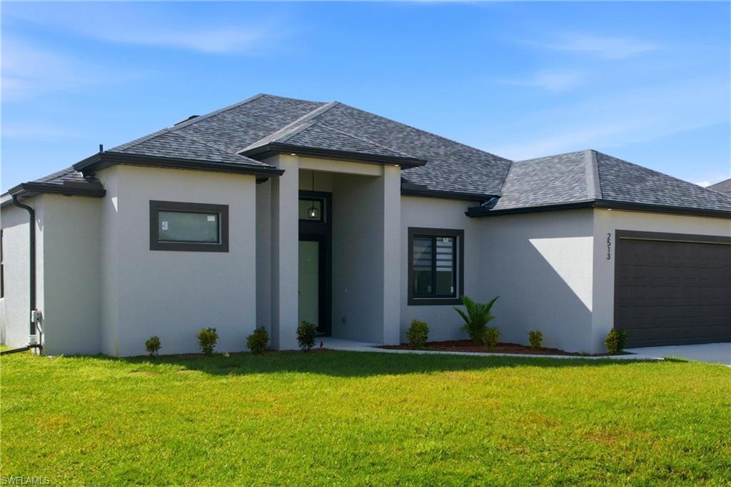 View of front of property featuring a front yard, an attached garage, stucco siding, and roof with shingles