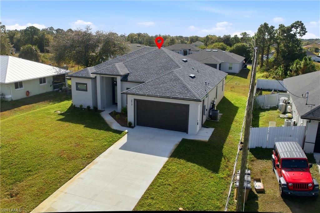 View of front of home featuring stucco siding, a shingled roof, driveway, and a garage