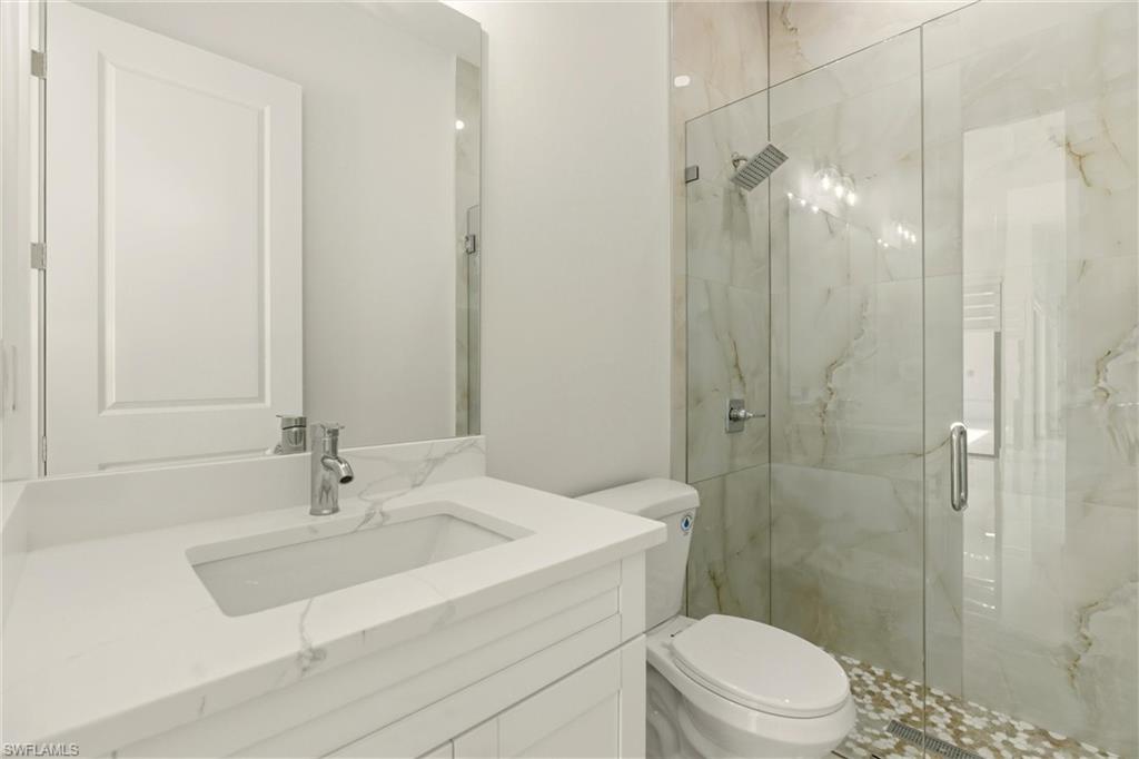 Full bathroom with vanity and a marble finish shower