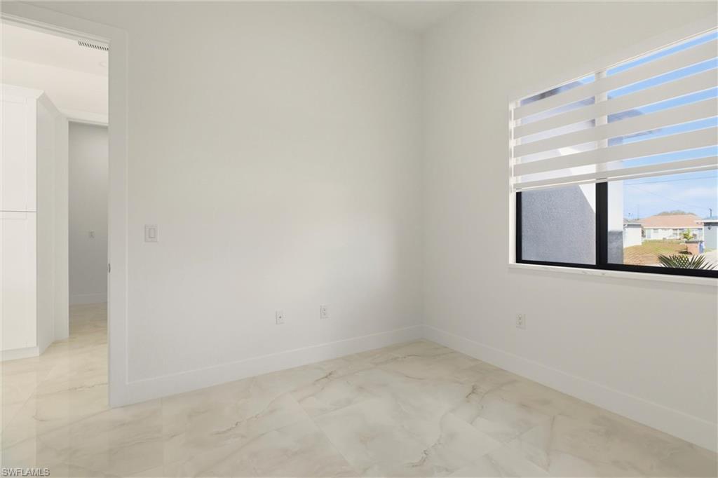 Spare room featuring light marble finish flooring