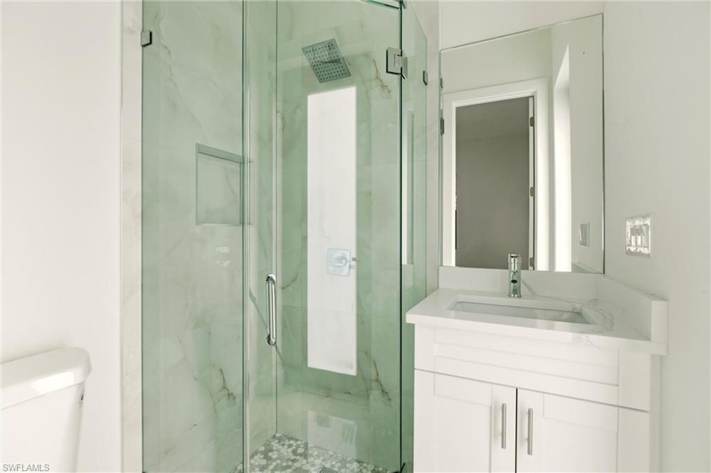 Bathroom with a marble finish shower and vanity