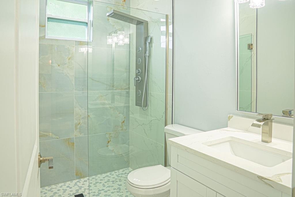 Full bath with a shower stall and vanity
