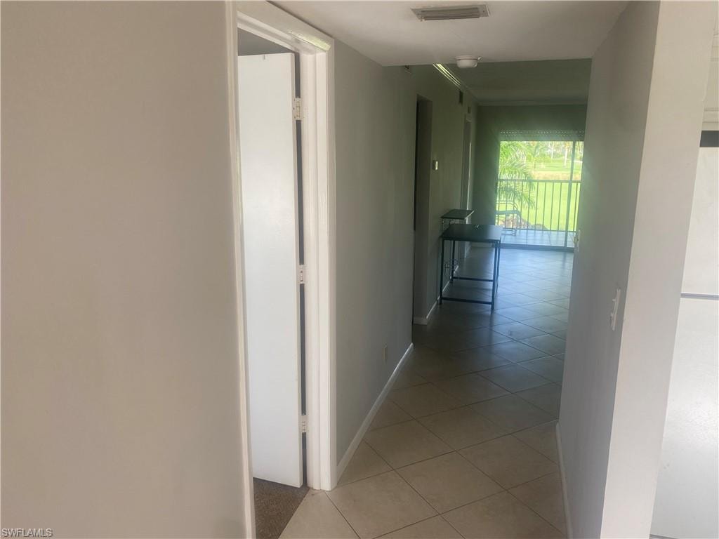 Hallway featuring light tile patterned floors and baseboards
