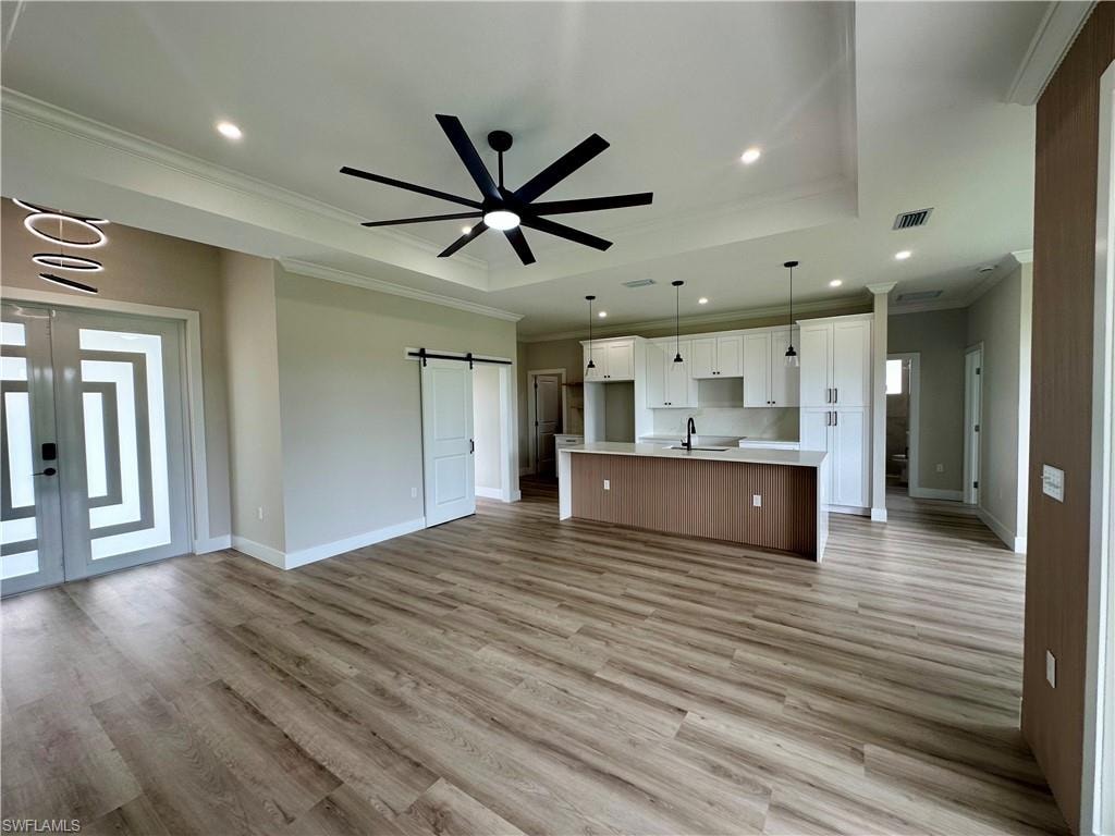 Kitchen featuring crown molding, appliances with stainless steel finishes, white cabinets, hanging light fixtures, and backsplash. Pictures virtually staged for illustrative purposes only