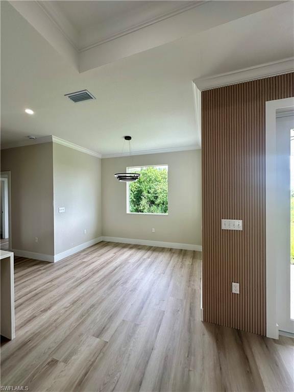 Unfurnished living room featuring a barn door, ornamental molding, a tray ceiling, recessed lighting, and light wood-type flooring