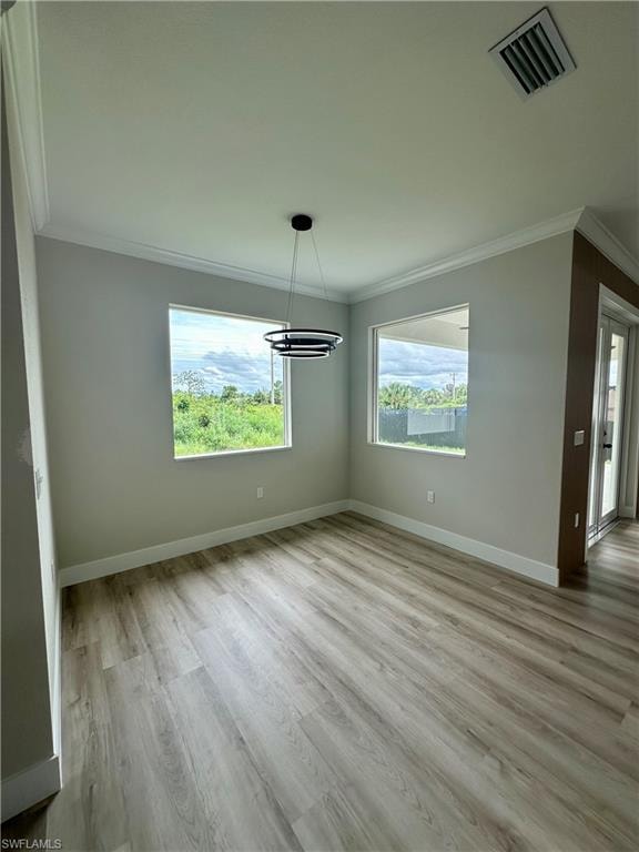 Kitchen with a tray ceiling, open floor plan, appliances with stainless steel finishes, white cabinetry, and hanging light fixtures