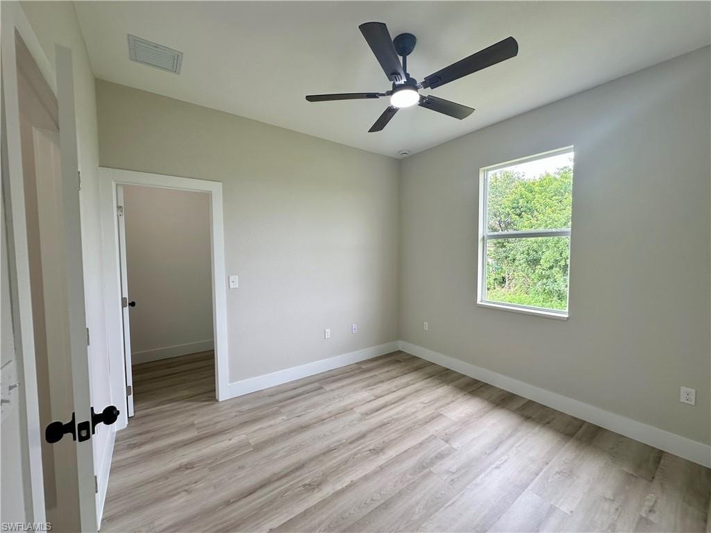 Unfurnished room with wood finished floors and ceiling fan