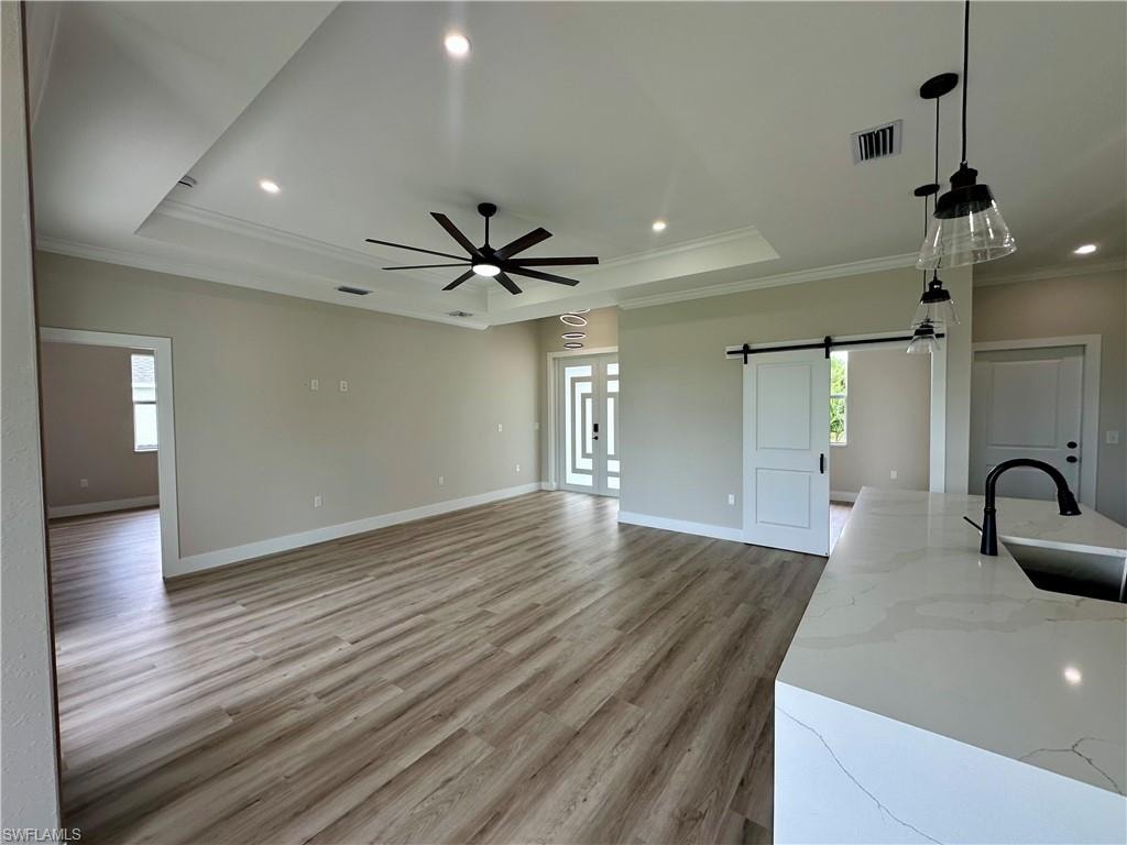 Bedroom featuring a raised ceiling, recessed lighting, light wood-type flooring, crown molding, and a ceiling fan. Pictures virtually staged for illustrative purposes only