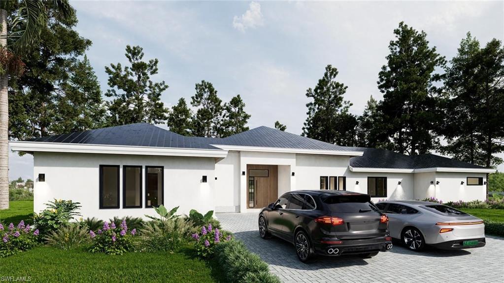 View of front of home with stucco siding, driveway, and a front lawn