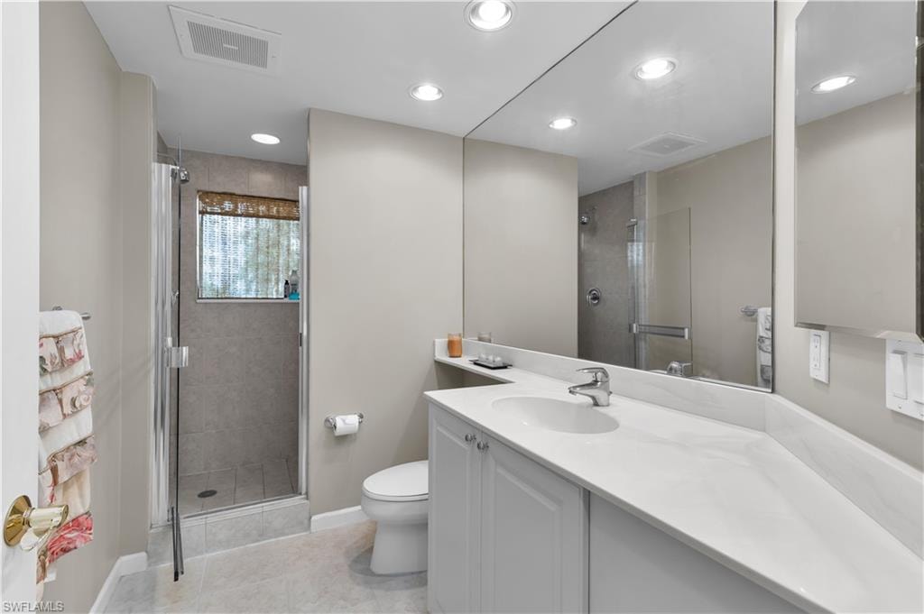 Full bathroom with a shower stall, vanity, tile patterned floors, and recessed lighting