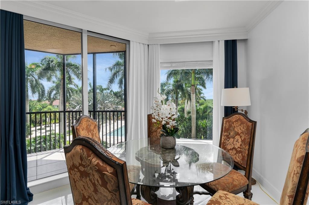 Dining room with crown molding and tile patterned floors