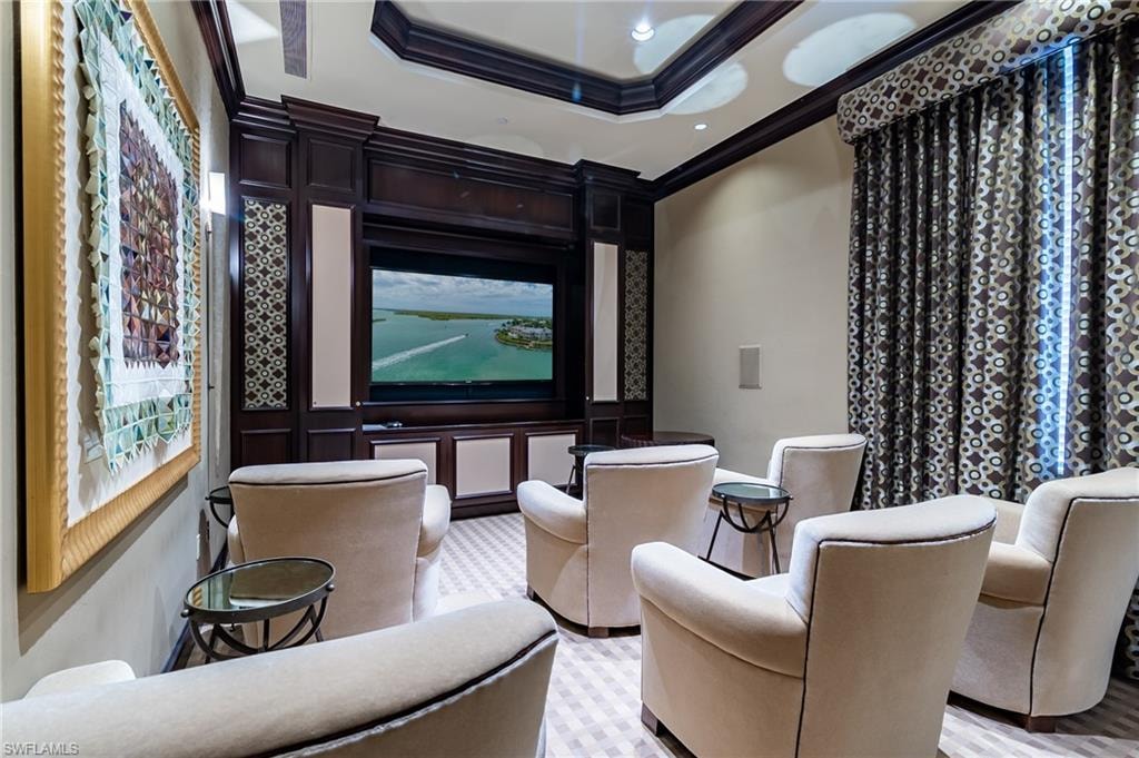 Cinema room featuring ornamental molding, a raised ceiling, and recessed lighting