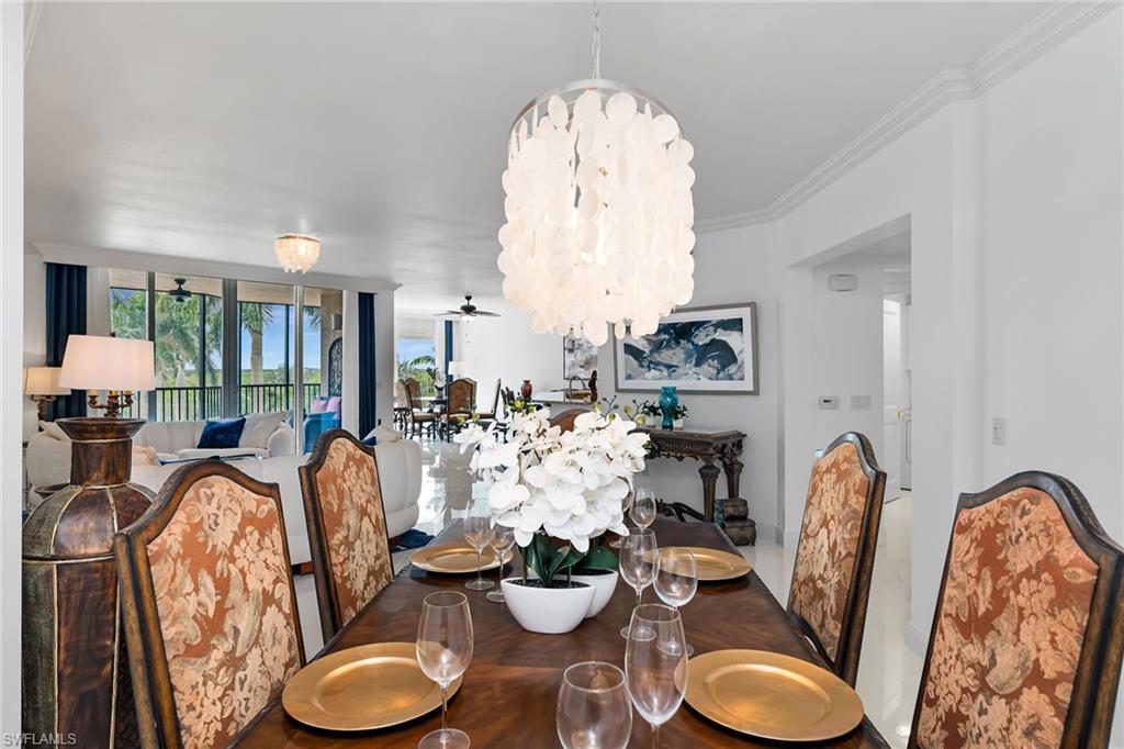 Dining space with a chandelier, crown molding, and ceiling fan