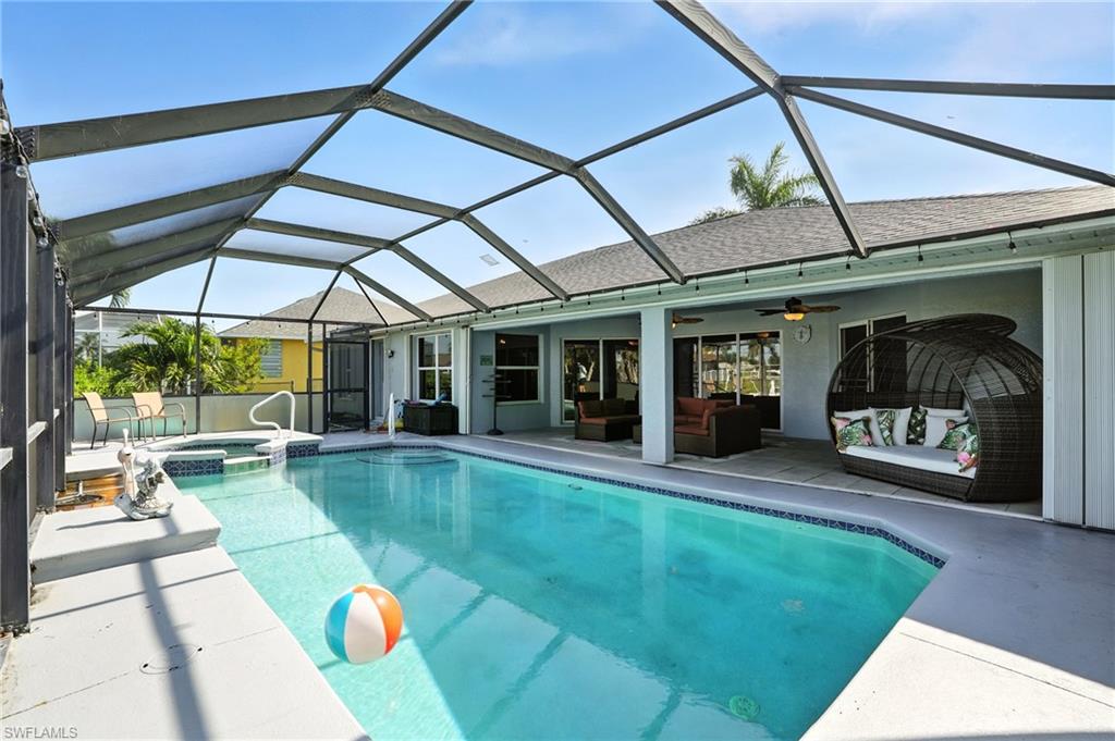 View of swimming pool with a lanai, outdoor lounge area, a patio area, and a pool with connected hot tub