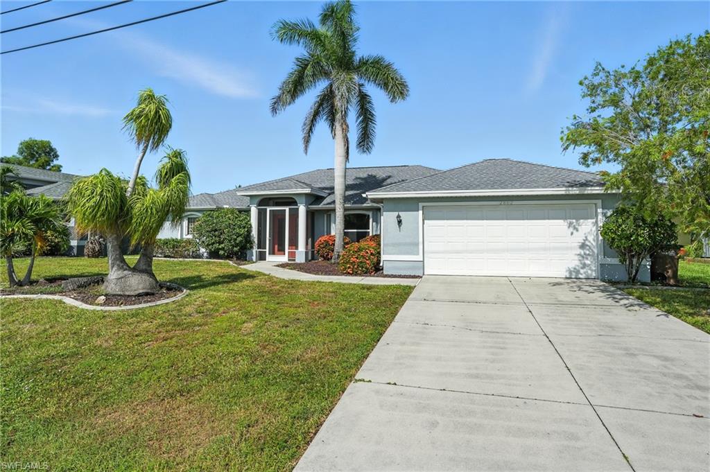 Ranch-style home featuring concrete driveway, an attached garage, a front yard, stucco siding, and a shingled roof