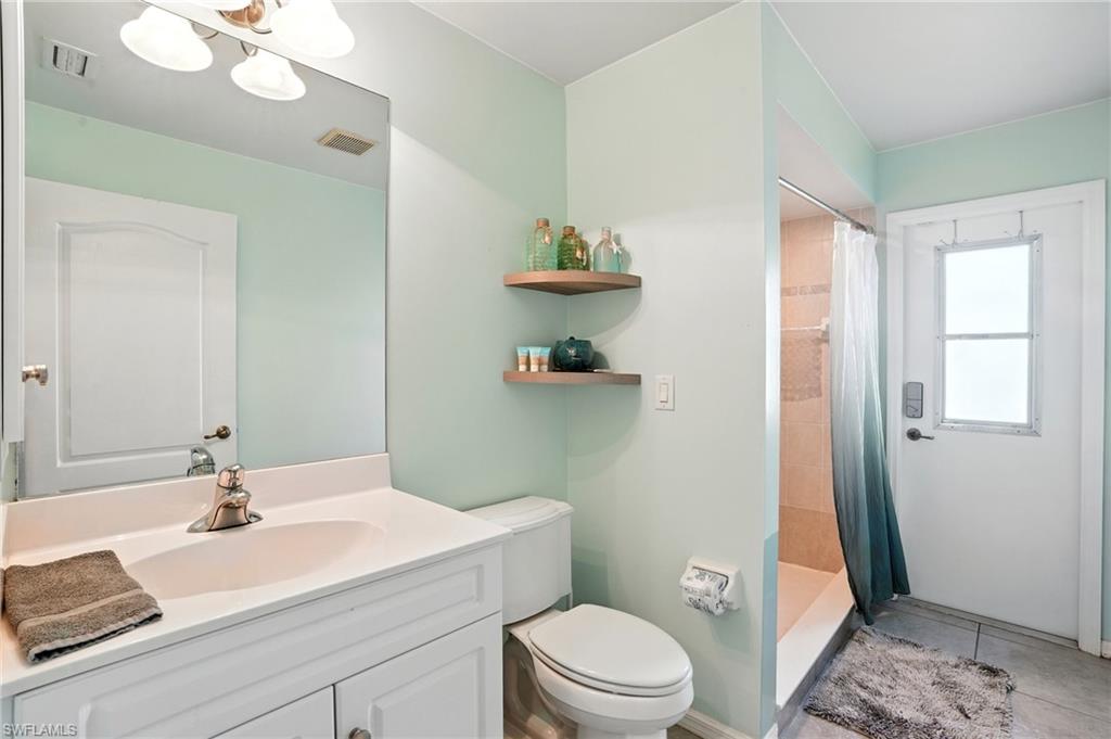 Full bathroom with vanity, tile patterned flooring, and a door out to pool area